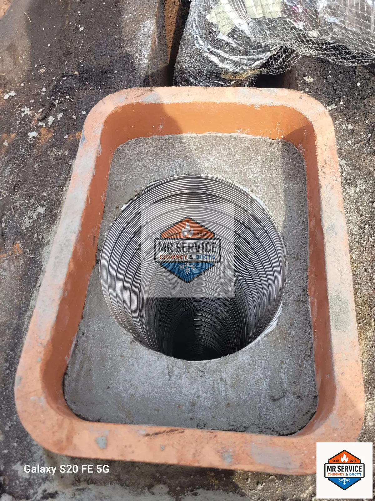 Stainless chimney liner visible inside a flue opening