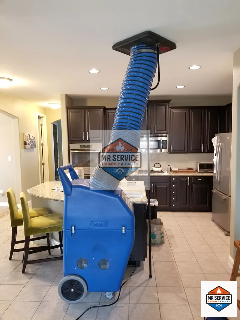 Negative air machine with hose set up below a ceiling vent